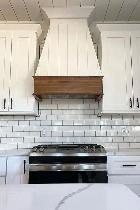 Kitchen design with Range Hood and white subway tile backsplash 