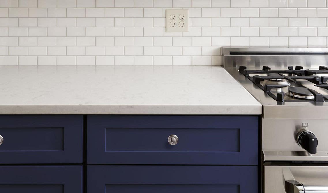 Navy blue cabinets paired with white subway tile