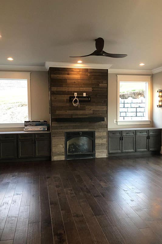 Fireplace surrounded by the reclaimed wood and driftwood storage cabinets