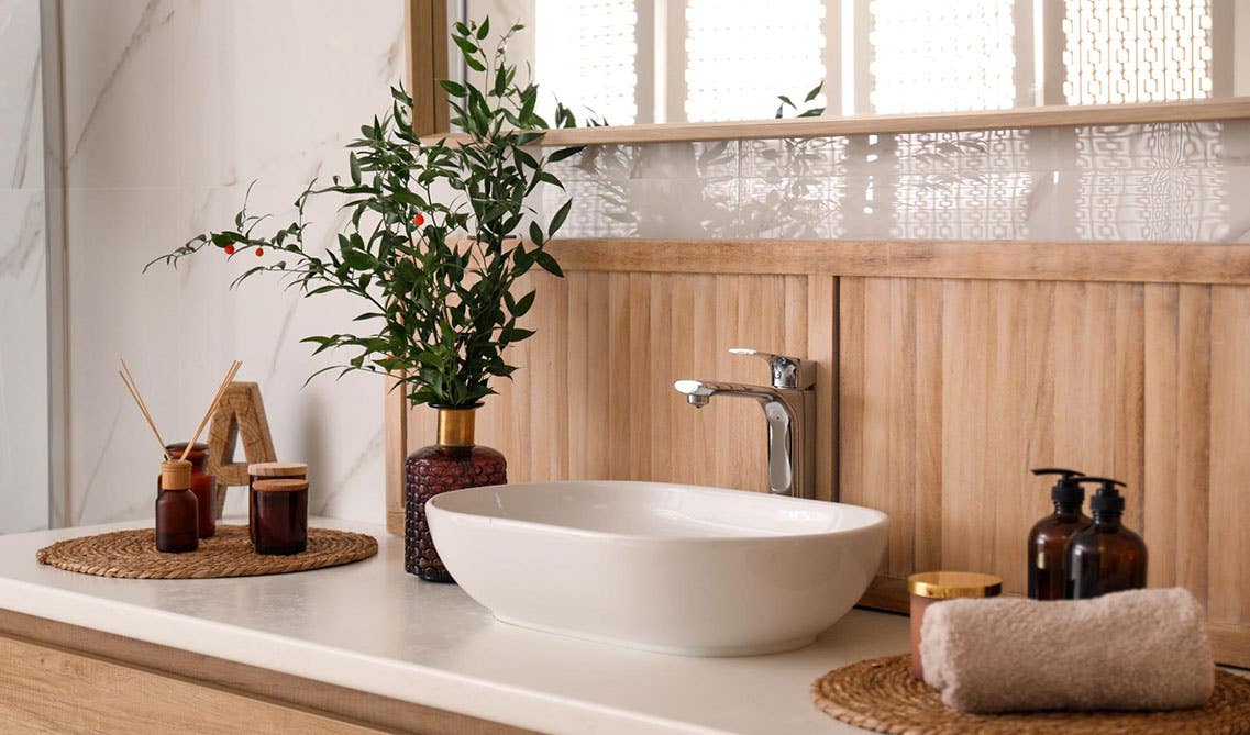 Bathroom design features Wood vanity with white countertop,ceramic wash basin with nature decor