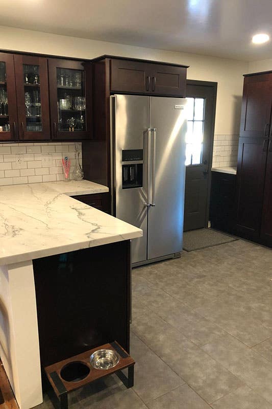 Kitchen with dark cabinets with stainless steel fridge