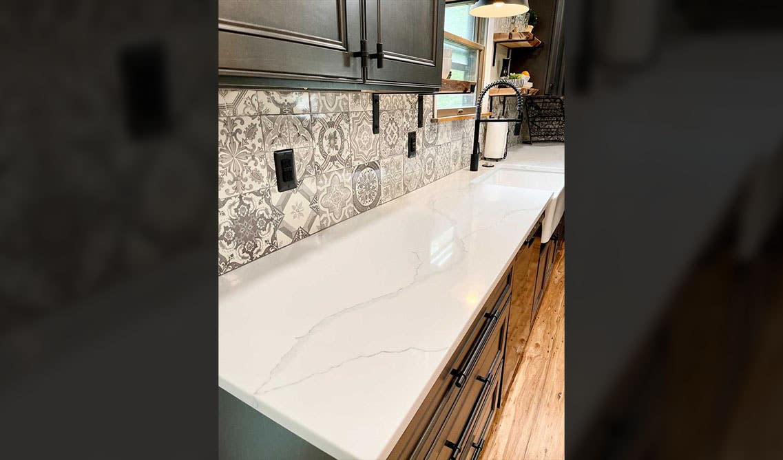 Dark cabinets with white countertop and design pattern tile backsplash, Farmhouse sink, open shelves 