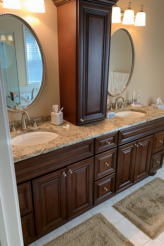Brown traditional linen cabinets paired with double sink, and quartz countertop