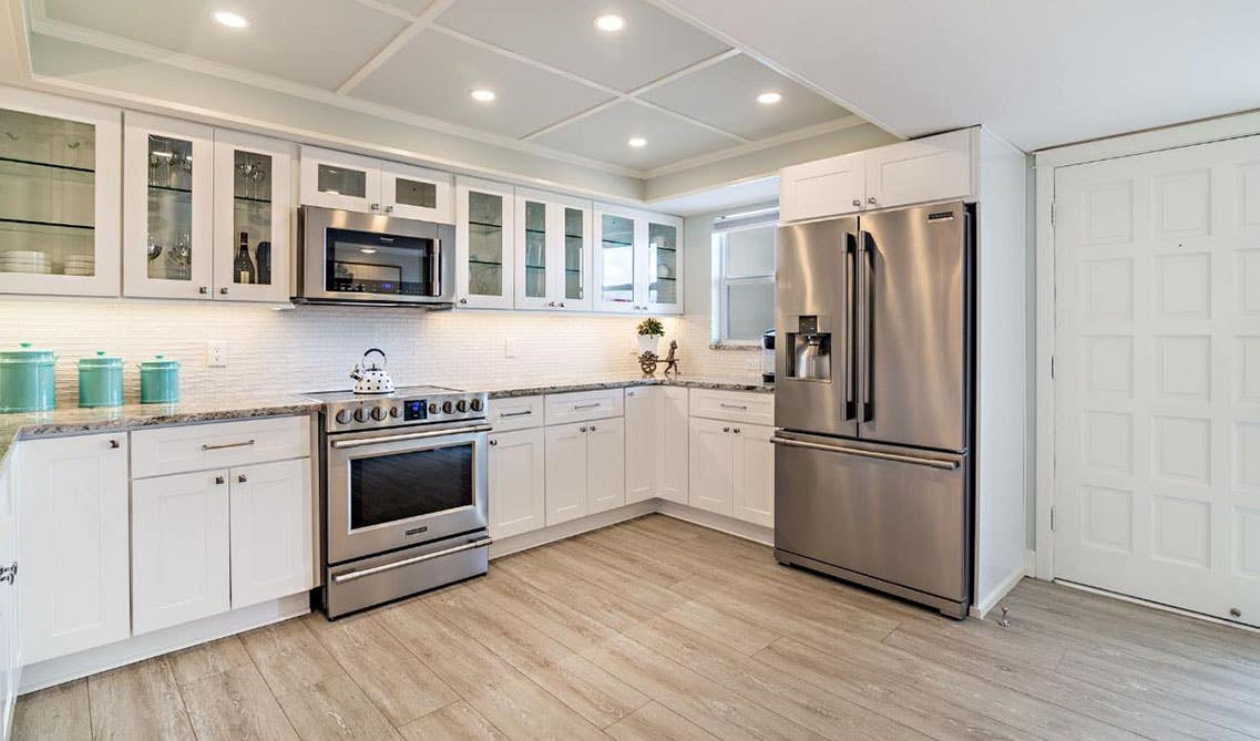 Traditional Kitchen with Glass Doors White Cabinets and Stainless Steel Appliances 