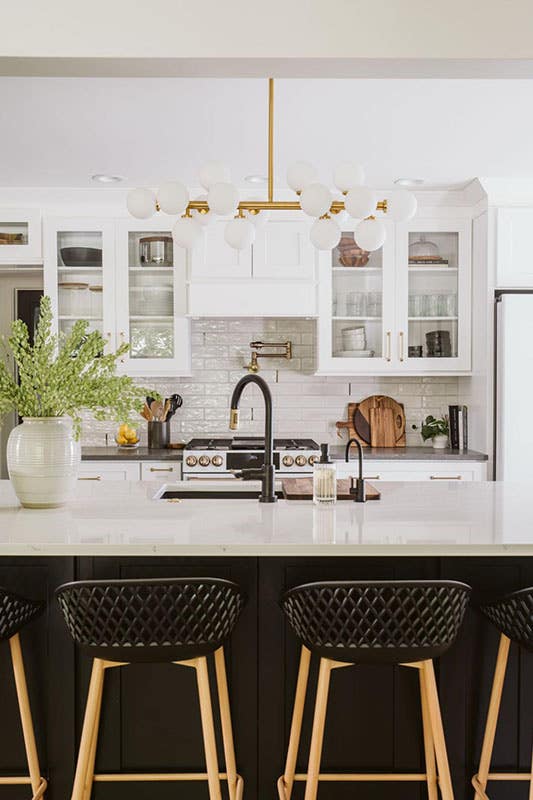 Traditional kitchen with wall glass white cabinets, island with undermount sink, matt black accent, and ceiling light