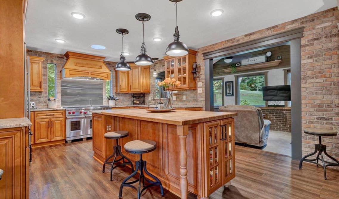 Traditional kitchen style with natural wood kitchen, pendant lights above large island, SPC Flooring