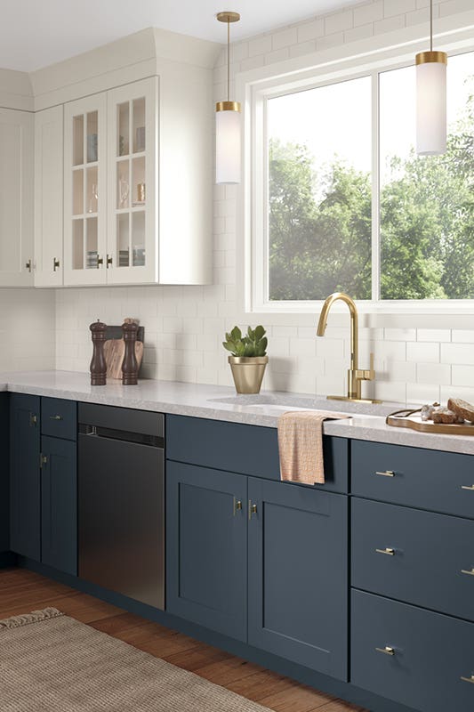 Two tone white and navy blue kitchen cabinets, paired with gold hardware