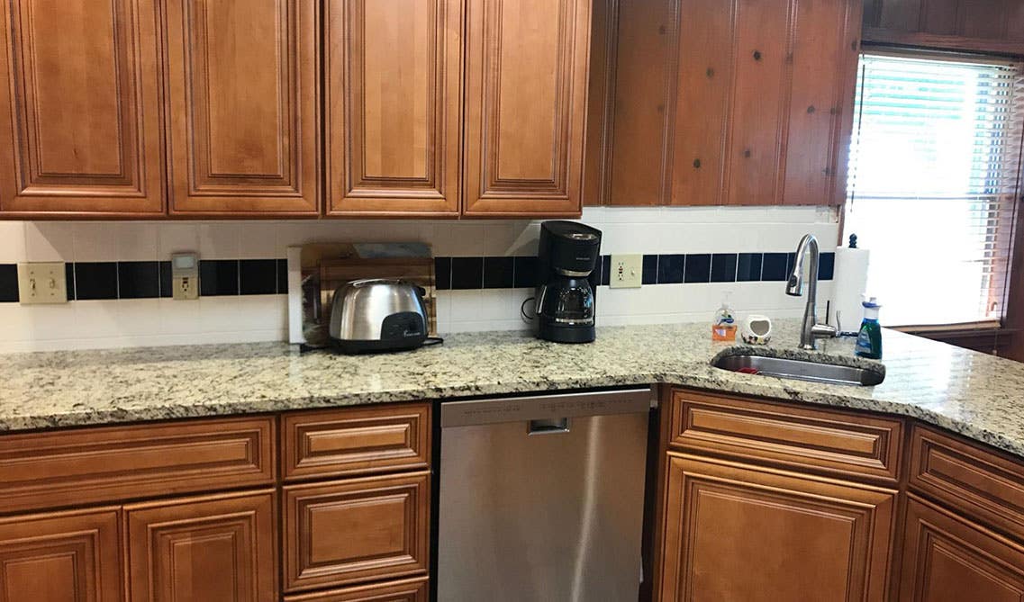 Undermount Corner sink with marble countertop and brown cabinets