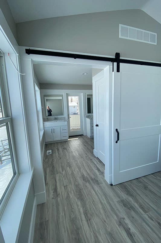 Bathroom with Sliding barn door, white vanity with sink and spc flooring