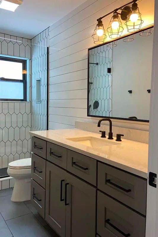 Bathroom with gray cabinets and matt black pulls