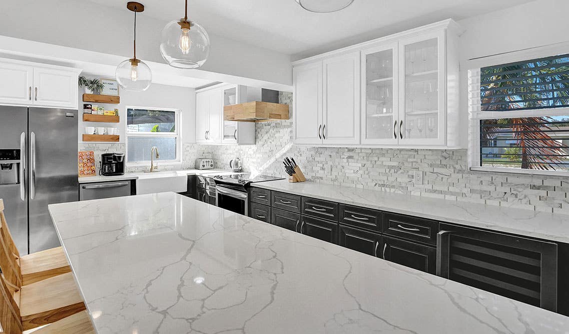 Farmhouse kitchen with Upper White Cabinets With Dark Grey Base Cabinets and marble white countertops