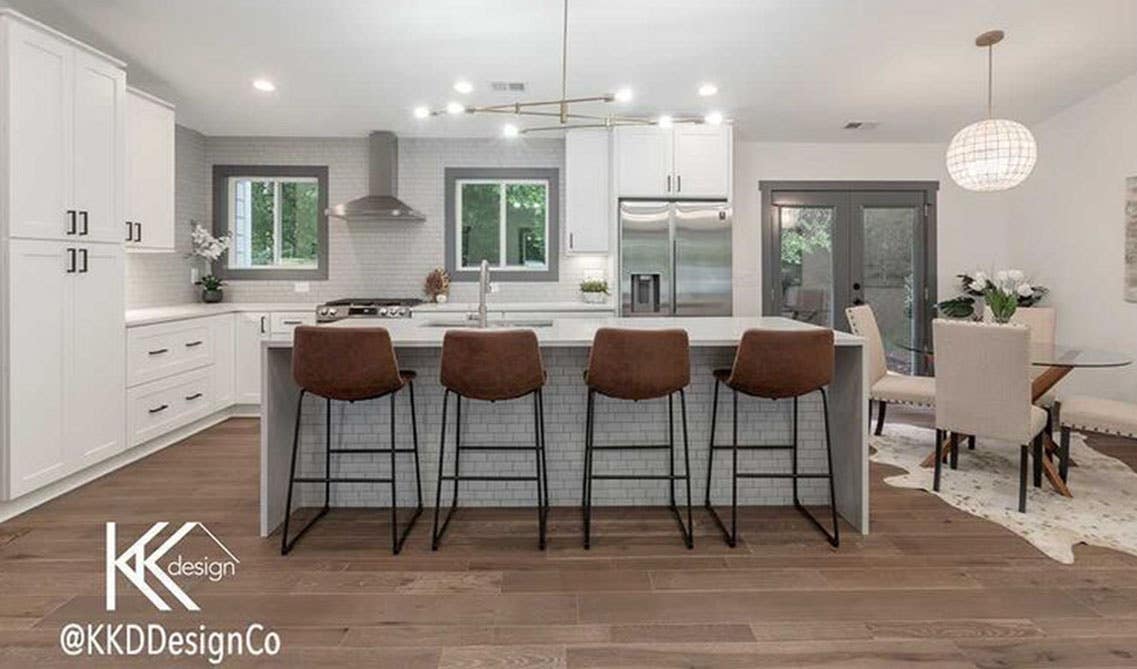 Modern kitchen style with white cabinets, large island, and beautiful ceiling lighting