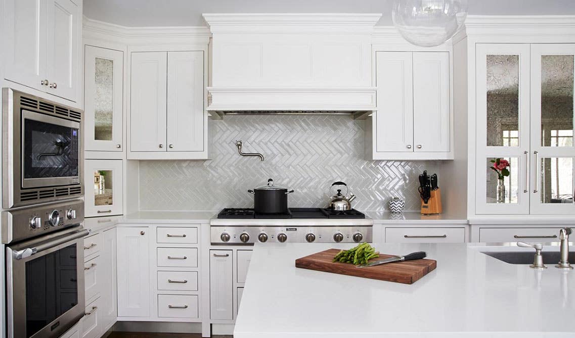 Vertical Herringbone Pattern subway tile paired with white kitchen