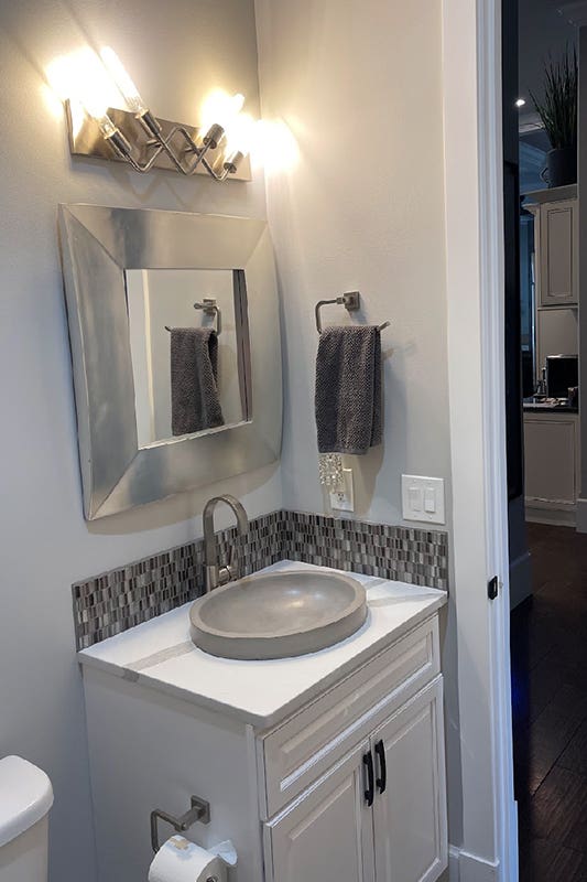 White bathroom vanity with Vessel sinks and mirror wall