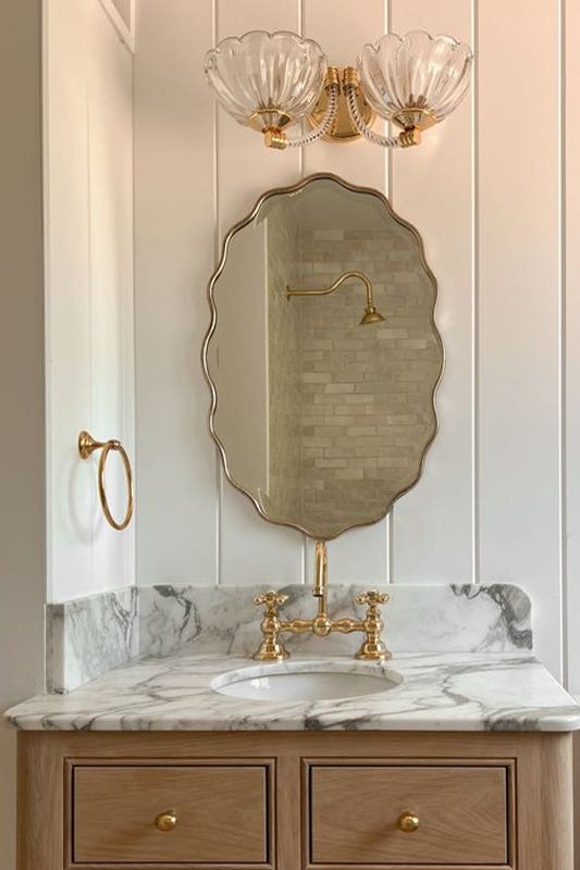 Vintage Accents bathroom design paired with vanity, gold hardware and antique mirrors 