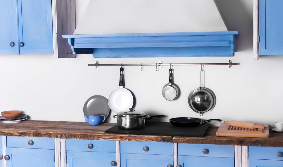 Vintage style kitchen with powder blue cabinets, and wood countertops.