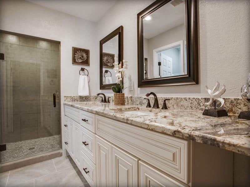 bathroom features cream vanity and quartz countertop with vintage faucet 