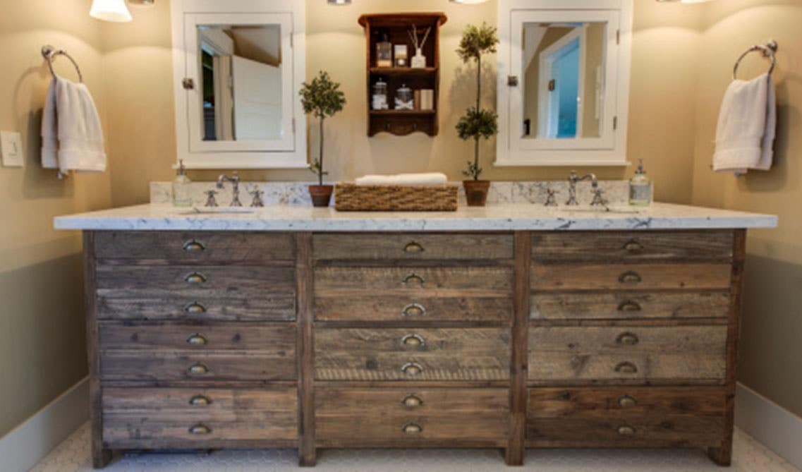 Small bathroom with natural wood bathroom vanity, mirror cabinet above sink, lamp light and towels on hanger