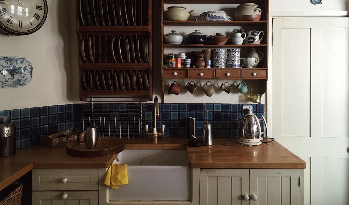 rustic kitchen design with gray cabinets, dark tone countertop and kitchen shelves