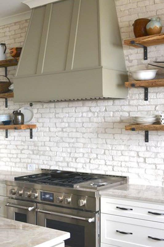 White Brick Veneer Backsplash with floating shelves and bright white cabinets