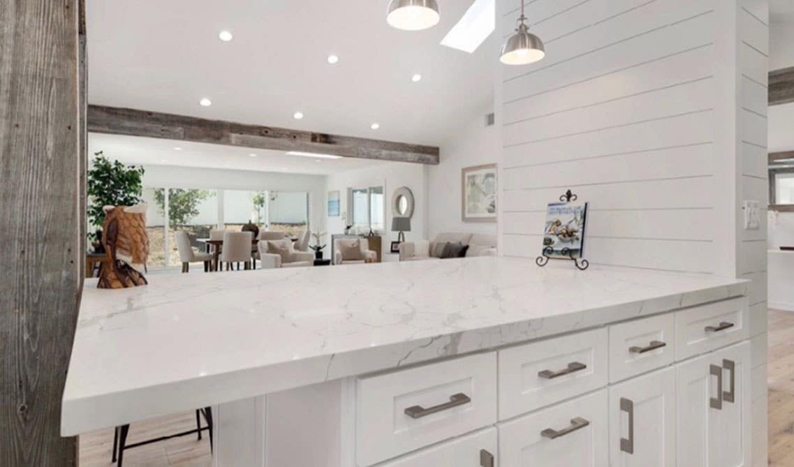 Kitchen island with white shaker cabinets and quartz countertop