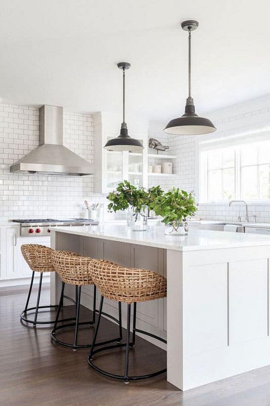 modern white kitchen with subway tile backsplash, large white island, and stainless steel appliances 