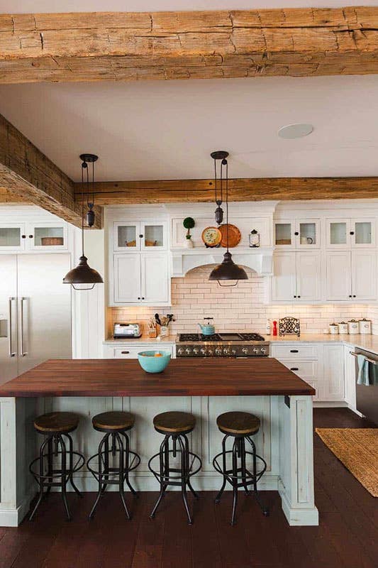 Farmhouse kitchen with white shaker cabinets, wood beams and white island