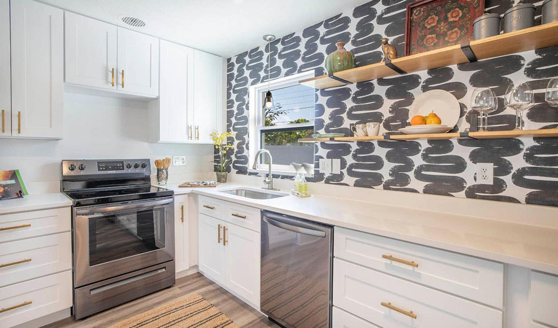 white shaker elite cabinets with gold hardware and floating shelves and accent wall