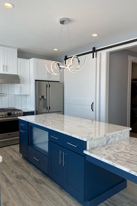 Two tone kitchen cabinets paired with statement lighting 