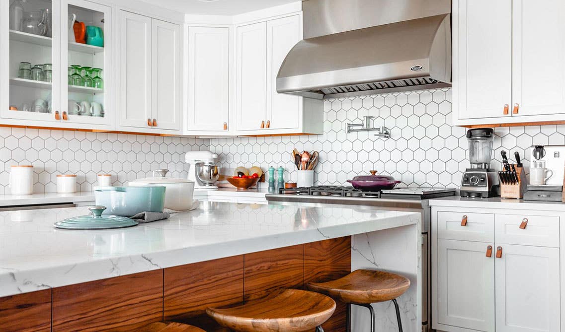 Farmhouse kitchen features White cabinets With a Wood Island and stainless steel appliances