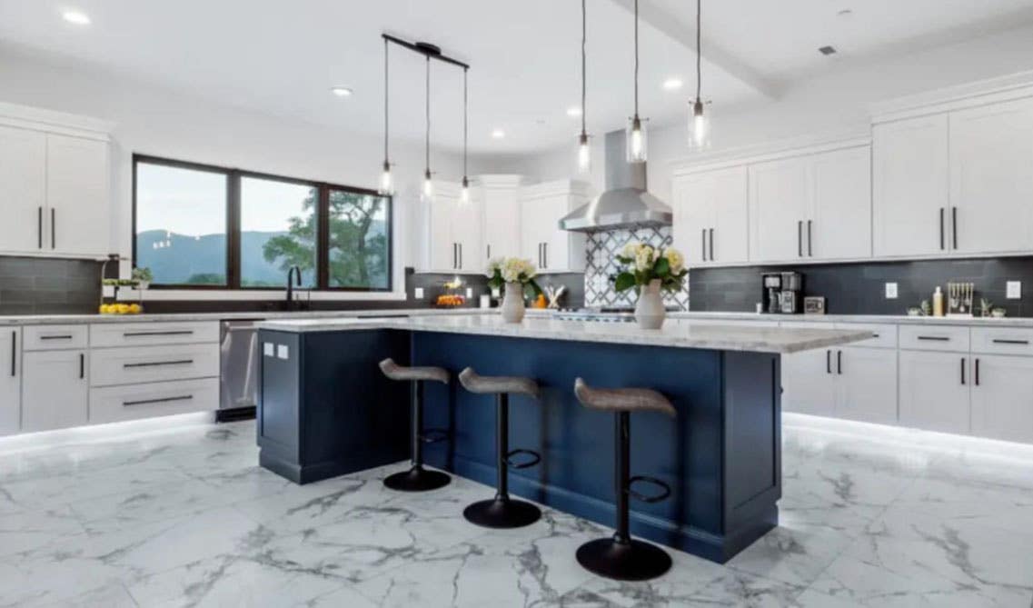 Navy blue island cabinets paired with white cabinets