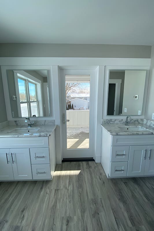 white bathroom cabinets paired with silver pulls and marble countertop