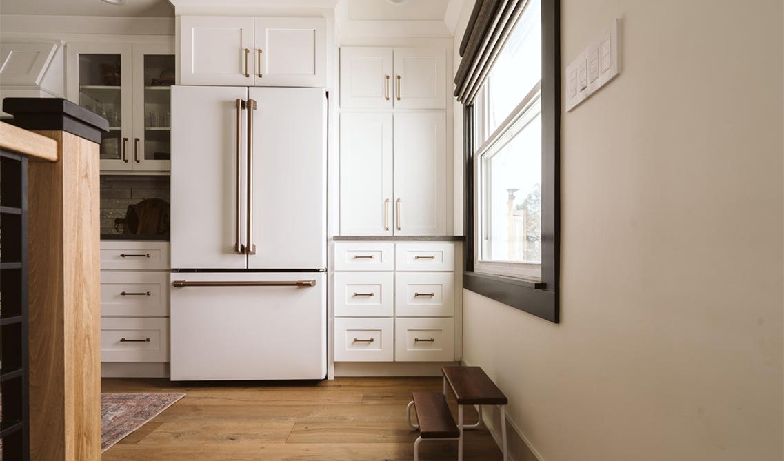 White kitchen cabinets with gold hardware and white appliances