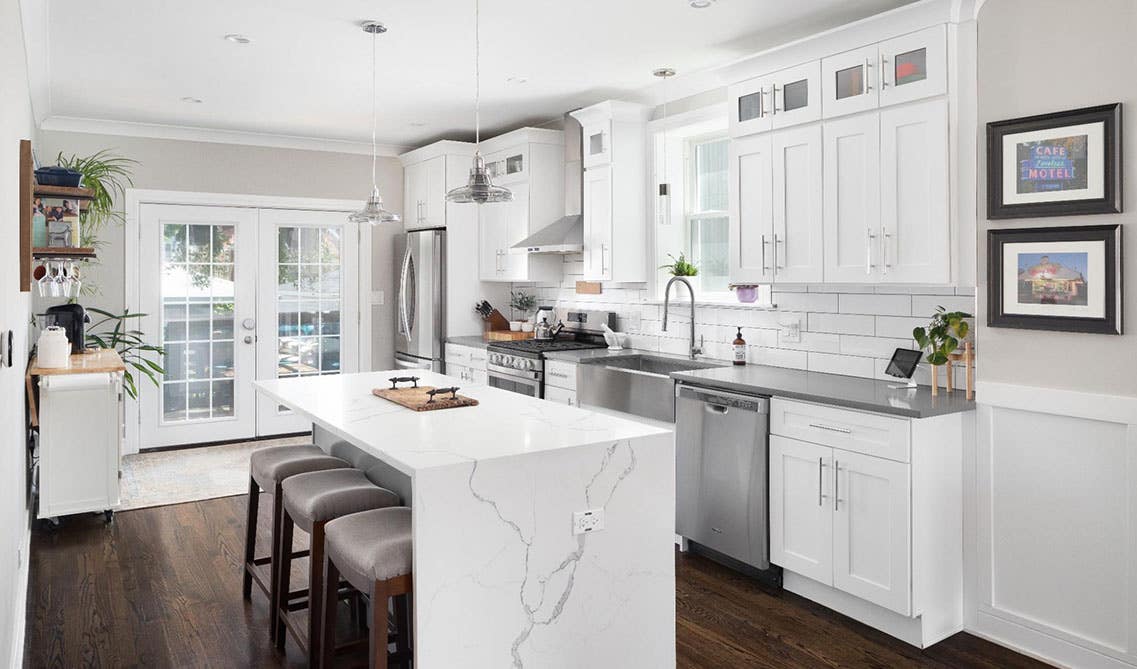 All white kitchen with shaker cabinets silver pulls and island with seating space, Stainless Steel Appliances