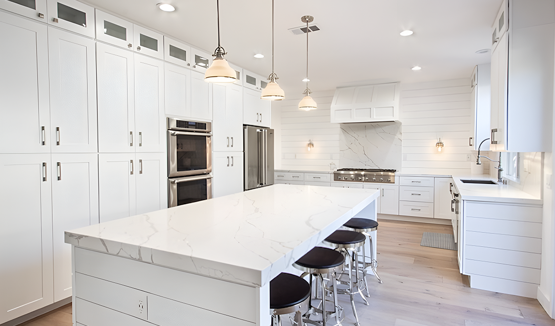 White shaker Cabinet kitchen with large island, sitting arrangement and pendent lights