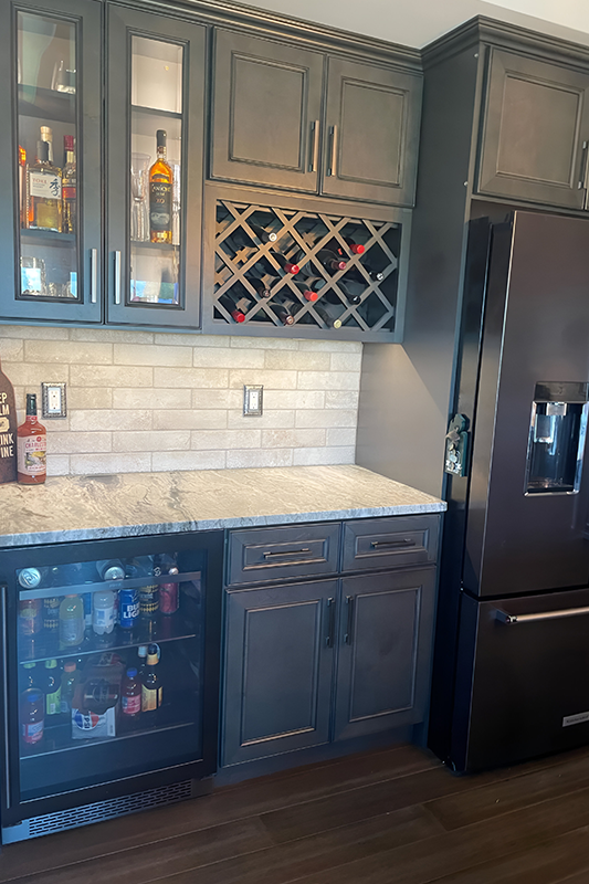 Wine storage driftwood gray cabinet paired with quartz countertop and subway backsplash 