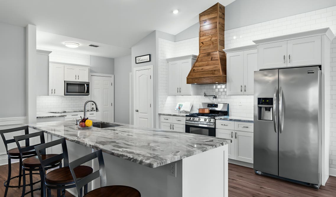 white kitchen with wood cabinets and natural wood range hood