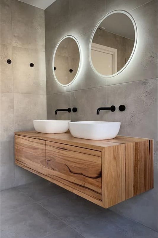 wooden floating vanity paired with black fixture and white sink