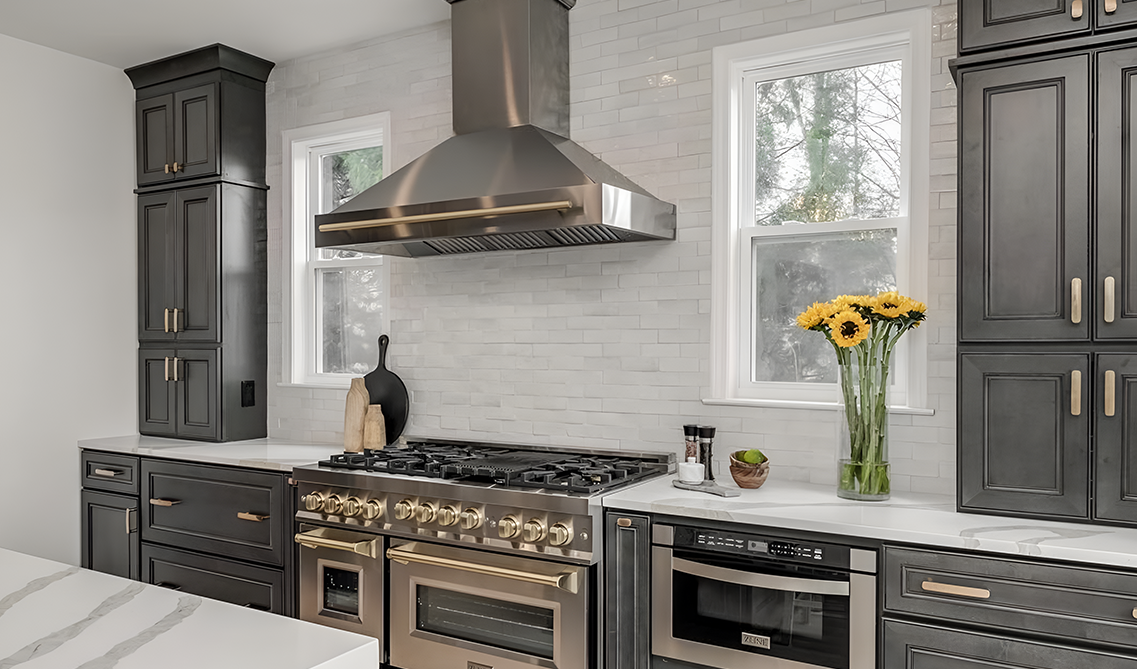 Single wall kitchen paired with dark cabinets, stainless steel appliances and marble countertop
