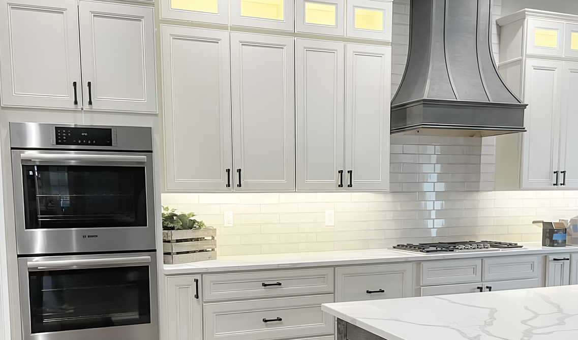 white kitchen featured linen cabinets, black hardware and stainless steel appliances 