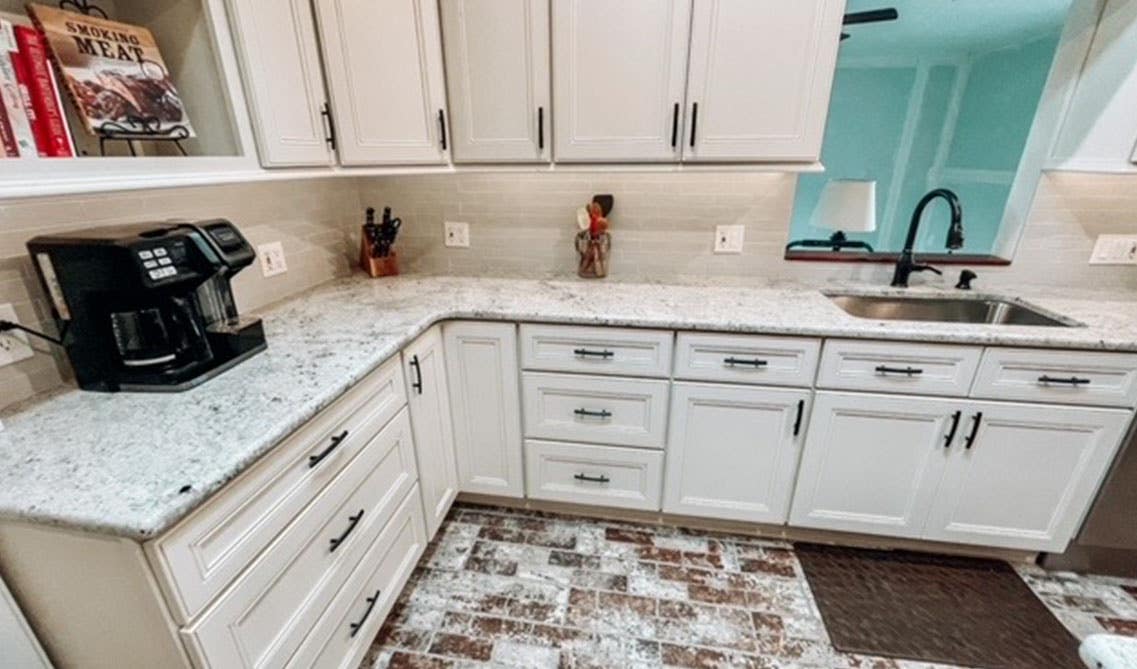 Linen cabinet with black hardware, faucet and appliances 