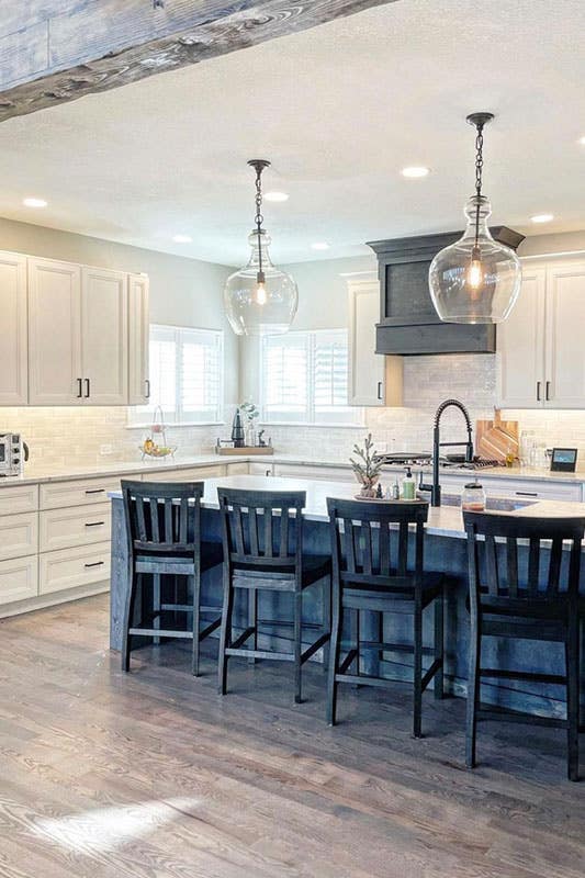 white linen cabinets feature with black accents like, island, hardware, hood, and ceiling lights