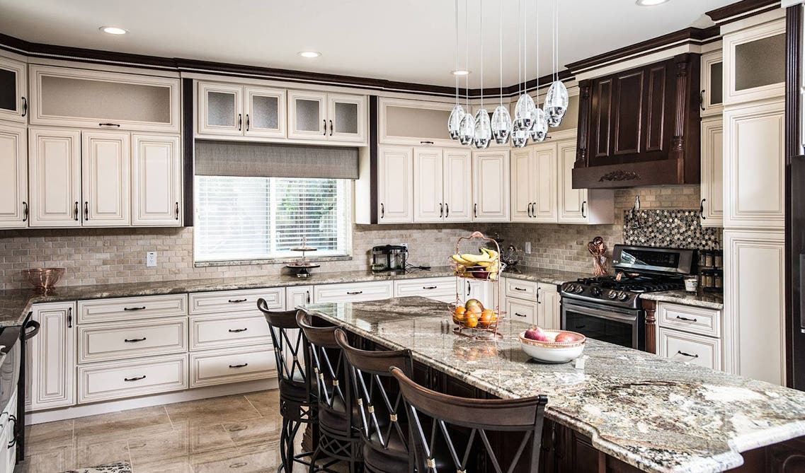 Countryside kitchen with linen cabinets with stainless steel appliances