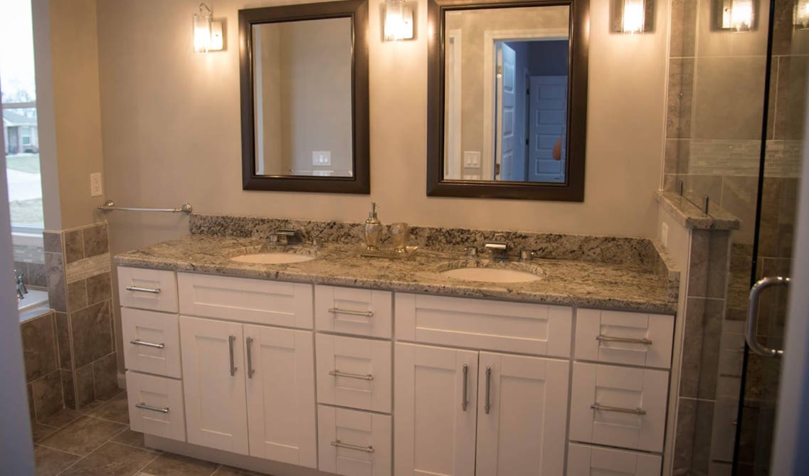 white bathroom vanities with 2 mirrors and towel hooks