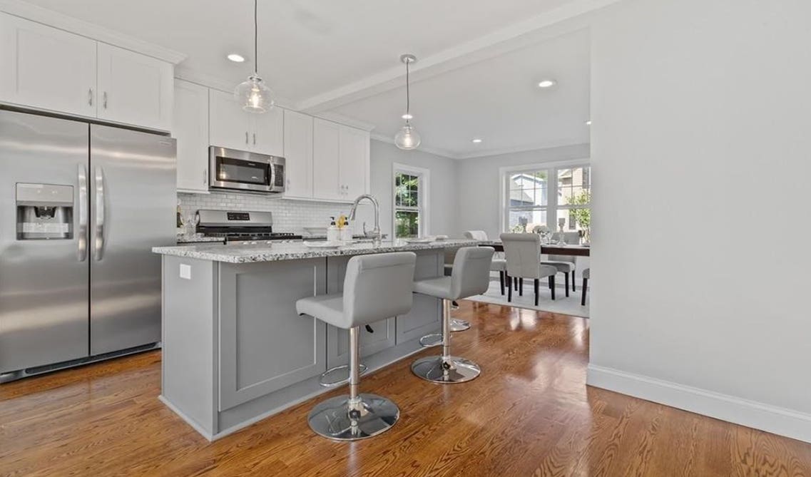 two tone gray and white cabinets kitchen with large island, decorative light