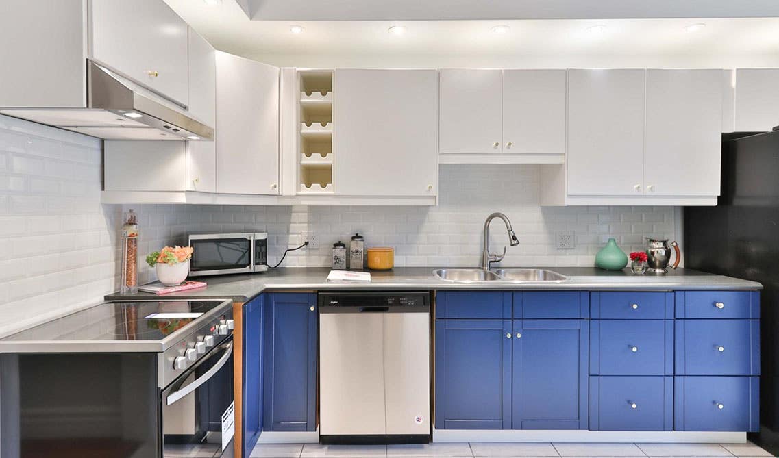Blue and white kitchen cabinets, crystal knobs, and stainless steel fixtures and 