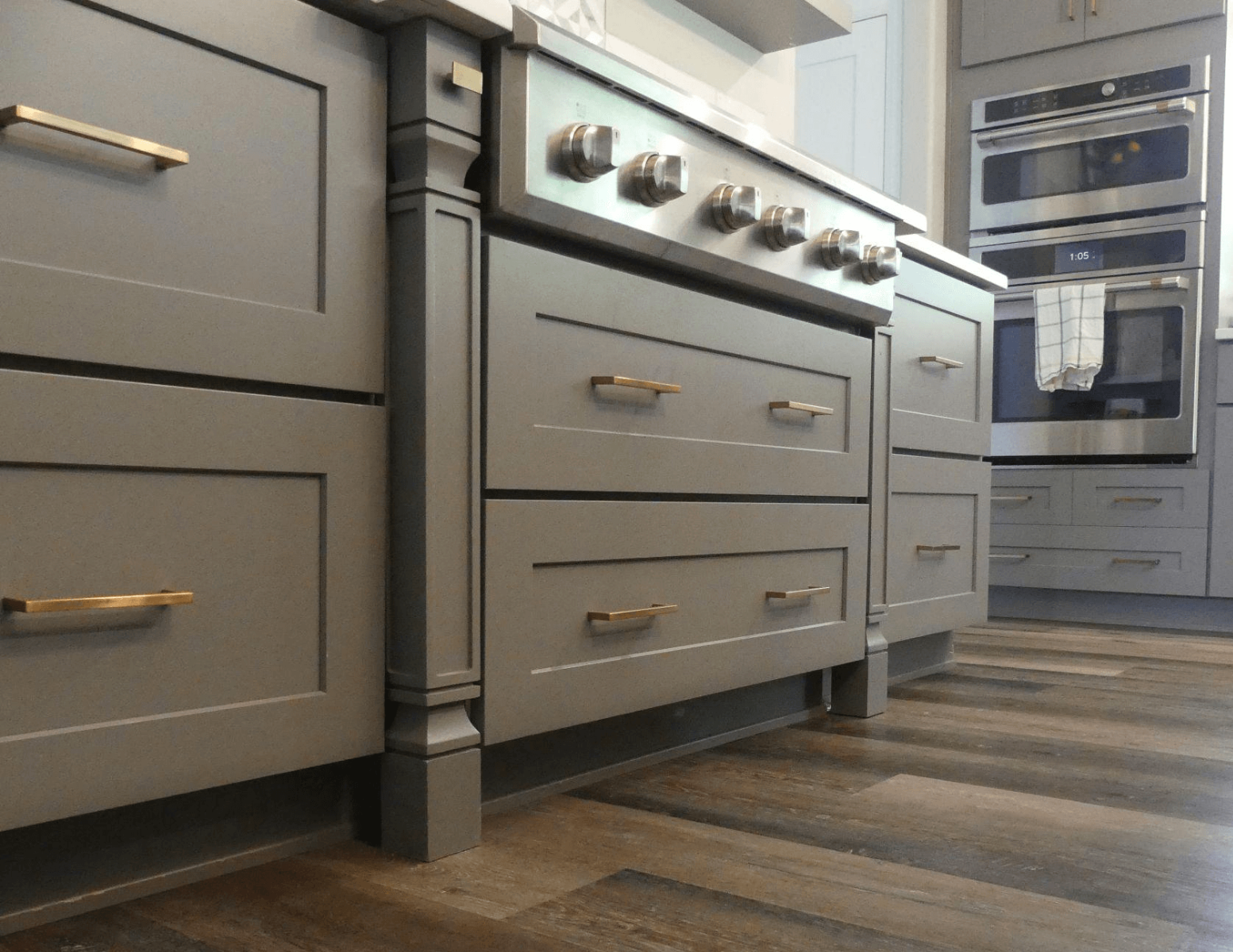 Gray base cabinets with gold pulls and spc flooring