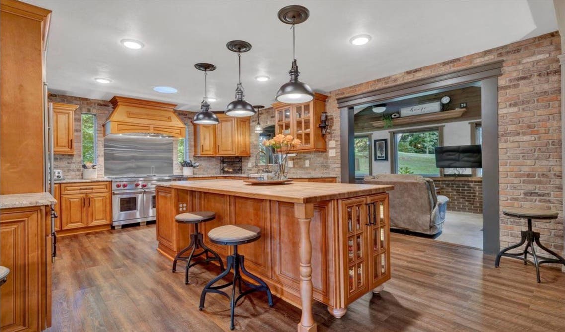 Glass front brown kitchen cabinets paired with stainless steel applainces