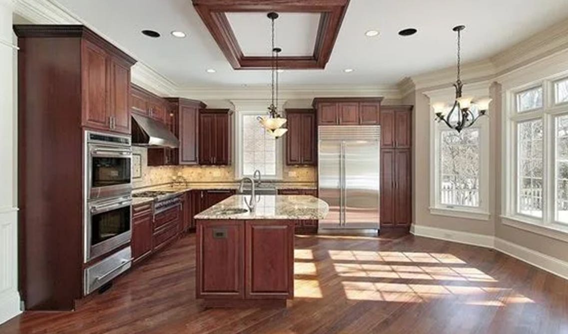 cherry cabinets with beige countertop and steel appliances 