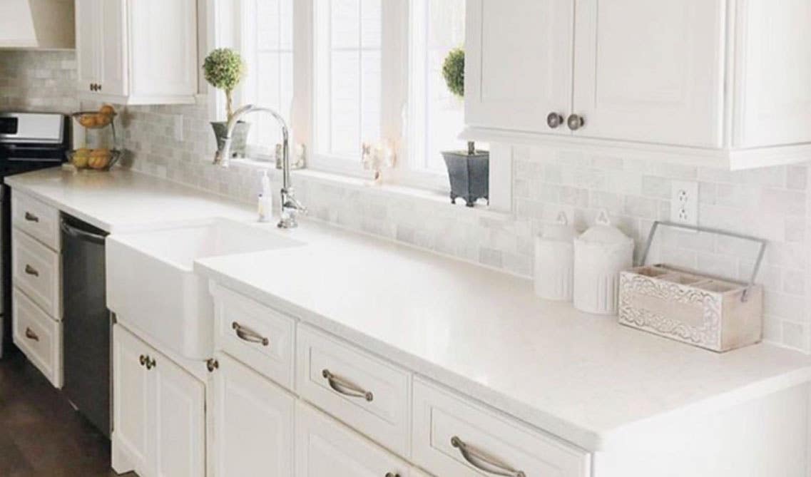 contemporary kitchen with white tile backsplash and marble countertop